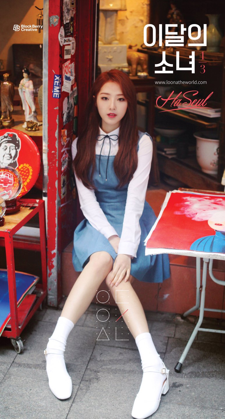Haseul sitting in front of a shop.